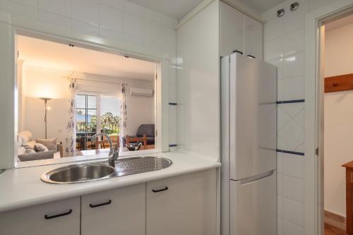 a kitchen with a sink and a refrigerator at Playa Grande - Playa Punta del Moral PPHG88P84 in Punta del moral