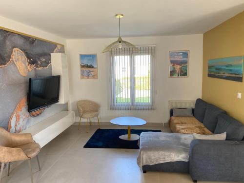 un salon avec un canapé et une télévision dans l'établissement Maison 3 chambres 