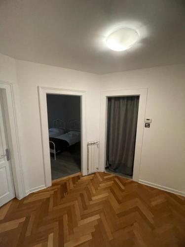 an empty room with a wooden floor and a bedroom at Vico 4 Charme Apartments in Trieste