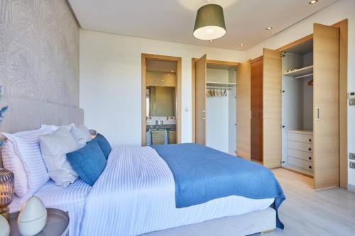 a bedroom with a large bed with blue and white pillows at Family-Friendly 3BR with Garden and Outdoor Space in Bouskoura