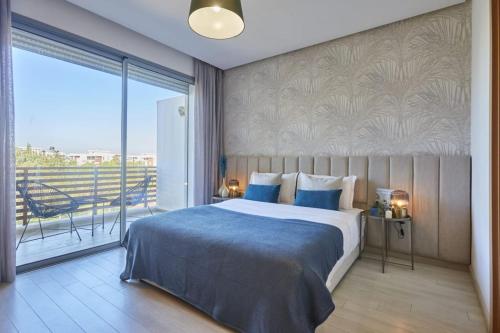 a bedroom with a large bed and a balcony at Family-Friendly 3BR with Garden and Outdoor Space in Bouskoura