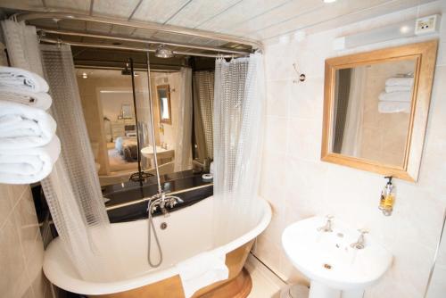 a bathroom with a tub and a sink at The Treebridge Hotel in Nunthorpe