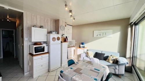 - une cuisine avec un canapé et une table dans une chambre dans l'établissement Vue océan imprenable, T2 de l'estacade, à Saint-Jean-de-Monts