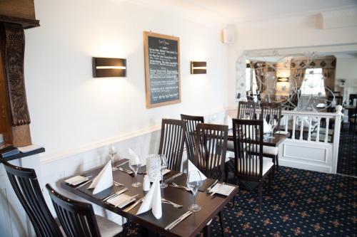 a dining room with a table and chairs in a restaurant at The Treebridge Hotel in Nunthorpe