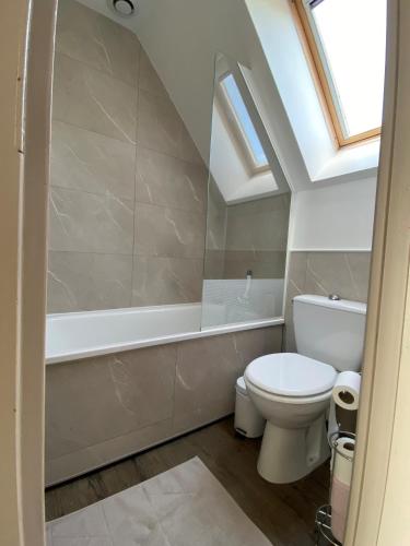une salle de bain avec toilettes et baignoire dans l'établissement Maison Belle Dune L'Île aux Oiseaux 34, à Quend-Plage