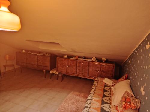 a attic room with a bed and two dressers at Casa di Francesca in Ruvo del Monte