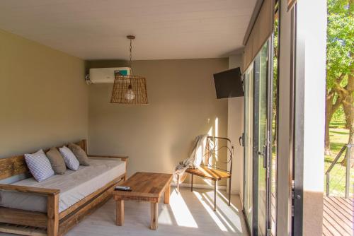 una sala de estar con un sofá y una mesa en La Quinta, Cabañas de campo, en Villa Nueva