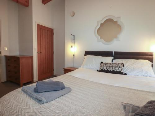 a bedroom with a large bed with a blanket on it at Tregullan in Truro