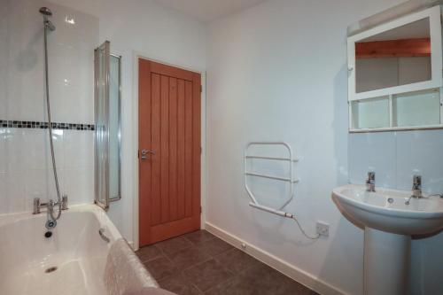 a bathroom with a tub and a sink and a shower at Tregullan in Truro