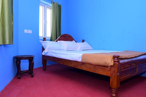 a bed in a room with a blue wall at Greenfields Pondicherry- An Eco-friendly farm stay in Villianur