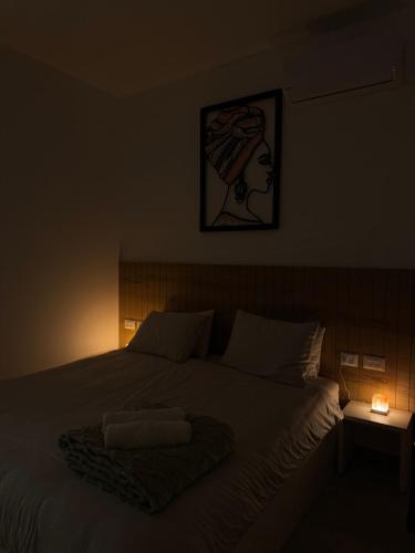 a bed in a dark room with a picture on the wall at Villa Alba in Majdal Shams