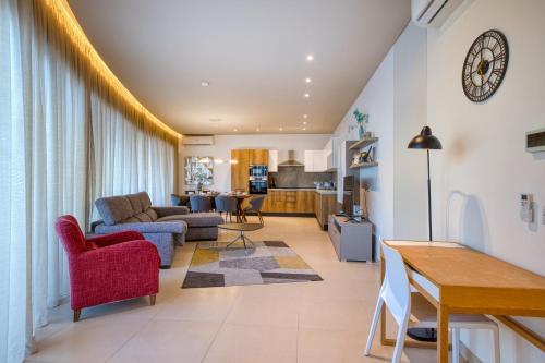 a living room with a couch and a table at Beautiful Penthouse with pool and terrace in Is-Swieqi