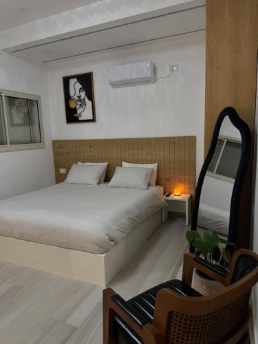 a bedroom with a large bed and a chair at Villa Alba in Majdal Shams