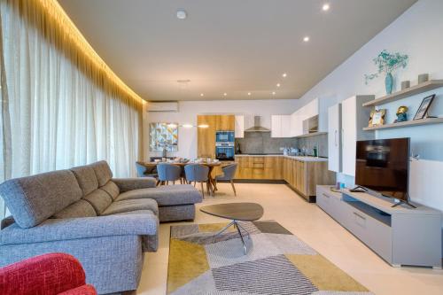 a living room with a couch and a table at Beautiful Penthouse with pool and terrace in Is-Swieqi