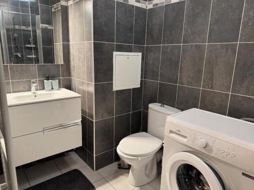 une salle de bain avec toilettes et lavabo et une machine à laver dans l'établissement Modern house Hyper centre CDG PARIS Parc Astérix, à Louvres
