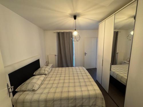 une petite chambre avec un lit et un miroir dans l'établissement Modern house Hyper centre CDG PARIS Parc Astérix, à Louvres