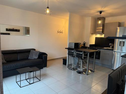 un salon avec un canapé et une cuisine dans l'établissement Modern house Hyper centre CDG PARIS Parc Astérix, à Louvres