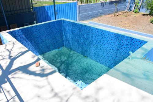 a swimming pool is shown with a blue at Greenfields Pondicherry- An Eco-friendly farm stay in Villianur