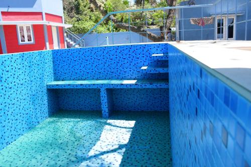 a blue wall with a bench on top of a building at Greenfields Pondicherry- An Eco-friendly farm stay in Villianur