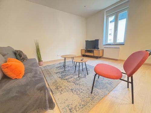 a living room with a couch and a table and chairs at Maréchal 1 Parking 4 Couchages in Clouange