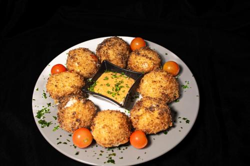 a plate of food with meatballs and tomatoes on a table at Casa Almarita - Hostal, Bar y Restaurante in Medellín