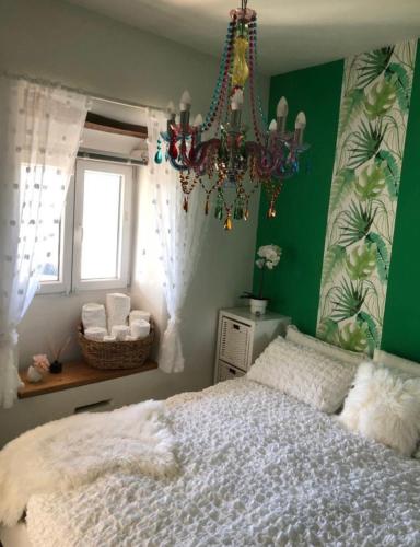 a bedroom with a bed and a chandelier at Ola Bella Vista in Figueiró dos Vinhos