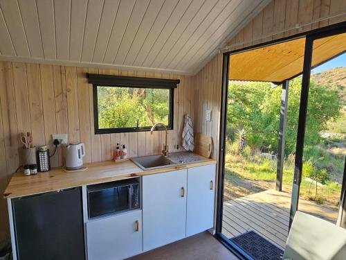 eine Küche mit einem Waschbecken und einem Fenster in einem Zimmer in der Unterkunft Fish Eagle River Camp in Vosburg