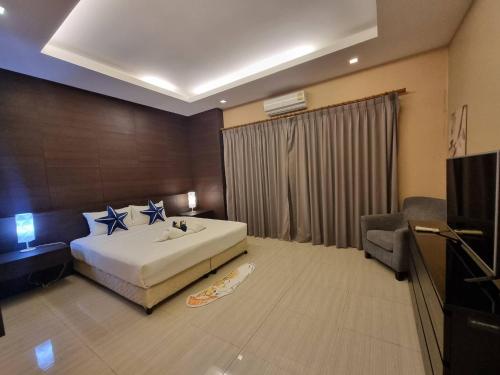 a hotel room with a bed and a television at Sea Life Poolville in Jomtien Beach