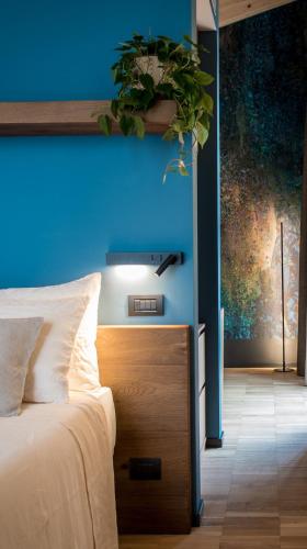 a bedroom with a blue wall and a bed at Terme Preistoriche Resort & Spa in Montegrotto Terme
