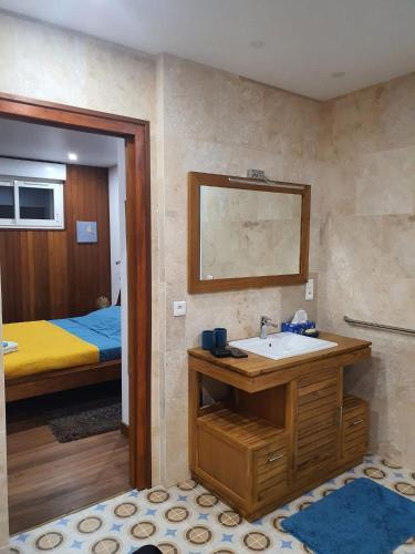 a bathroom with a sink and a bed at Le Paradis de la Guadeloupe in Pointe-Noire