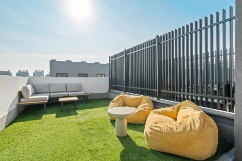 a balcony with two couches and chairs on a roof at atico duplex con piscina y parking incluido ALQUILER TEMPORAL in San Sebastián de los Reyes