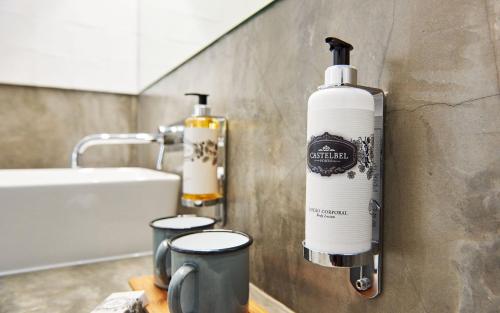 a bottle on a wall in a bathroom at Casas da Praia - Casas da Amieira in Amieira