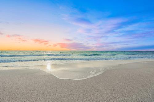 a sandy beach with the ocean and a cloudy sky at Modern beachfront condo in Sarasota