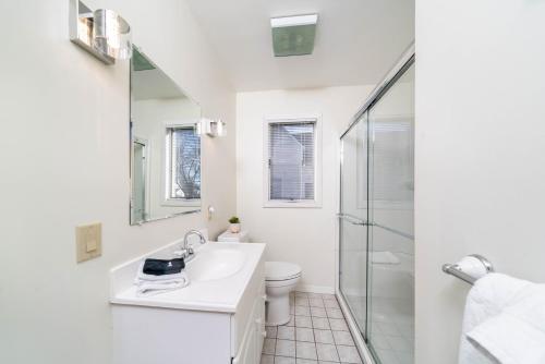 a white bathroom with a sink and a toilet at 5 Bedroom with Fire Pit, Patio & Large Yard in South Haven