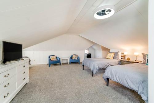 a attic bedroom with two beds and a flat screen tv at 5 Bedroom with Fire Pit, Patio & Large Yard in South Haven