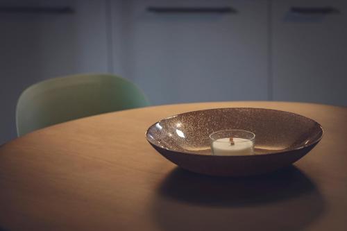 a candle in a bowl on a wooden table at Hotel Villa Alberta in Nago-Torbole