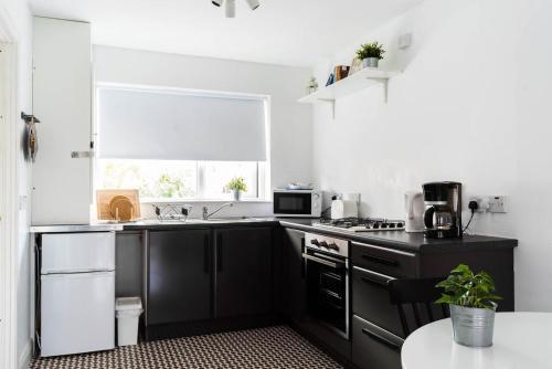 a kitchen with black and white appliances and a window at Amica Guesthouse in Belfast