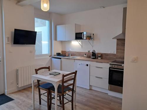 une petite cuisine avec une table et deux chaises dans l'établissement Studio 3 Cozy Proche du centre ville, à Rochefort