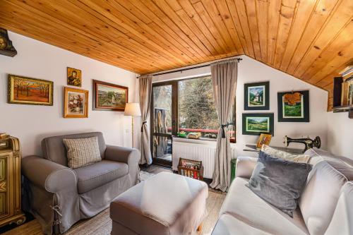 a living room with a couch and a chair at Casa cu Amintiri - Authentic Cozy Cottage in Bran