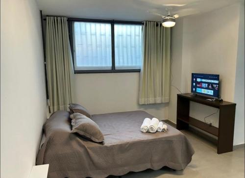 a bedroom with a bed and a television in it at 13 Studio completo, perto TRT, Smartfit, Life Center, cozinha in Belo Horizonte