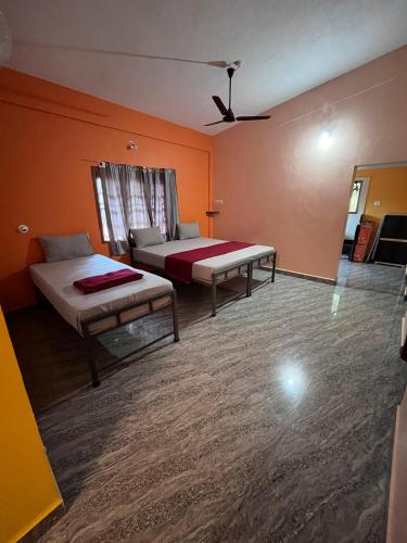 a room with two beds and a couch in it at HostelVK Gokarna in Gokarna