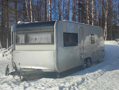 a silver trailer is parked in the snow at Northern Lights Camper in Rovaniemi