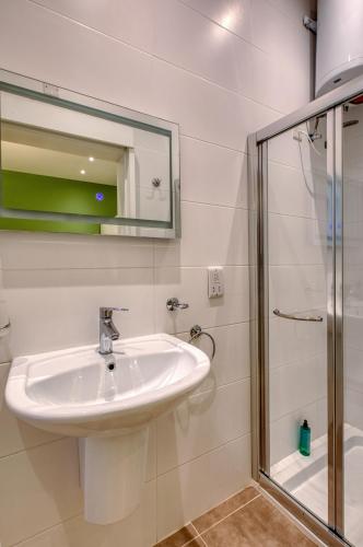 a bathroom with a sink and a shower at Beautiful Penthouse with pool and terrace in Is-Swieqi