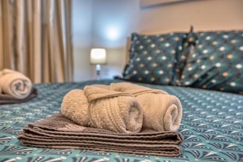 a pile of towels sitting on top of a bed at Beautiful Penthouse with pool and terrace in Is-Swieqi
