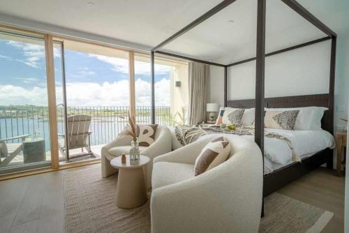 a bedroom with a large bed and a balcony at 3 Bedroom Luxury Waterside House in Hayle