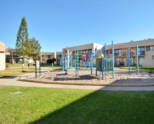 a playground in a park in front of a building at Riverview Holiday Apartment 3 - Kalbarri WA in Kalbarri