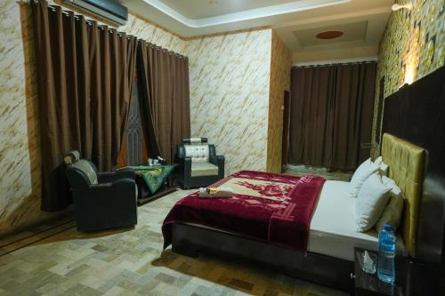 a bedroom with a bed and a chair in a room at Hotel the Lodges inn in Multan