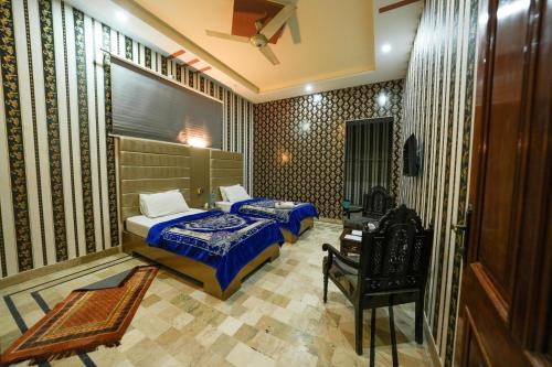 a bedroom with a bed and a chair in it at Hotel the Lodges inn in Multan