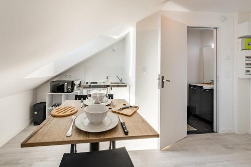 une salle à manger avec une table en bois avec une tasse et une assiette dans l'établissement La scène - Wifi Université, à Angers