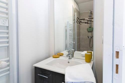 une salle de bain blanche avec un lavabo et une douche dans l'établissement La scène - Wifi Université, à Angers